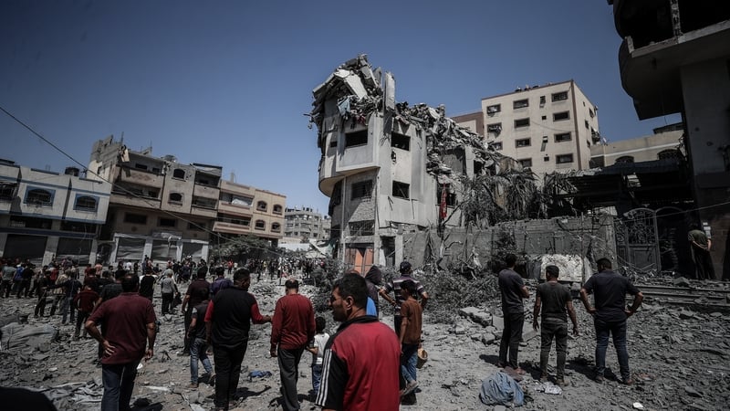 Palestinians examine the rubble of heavily damaged buildings following an Israeli attack in central Gaza City