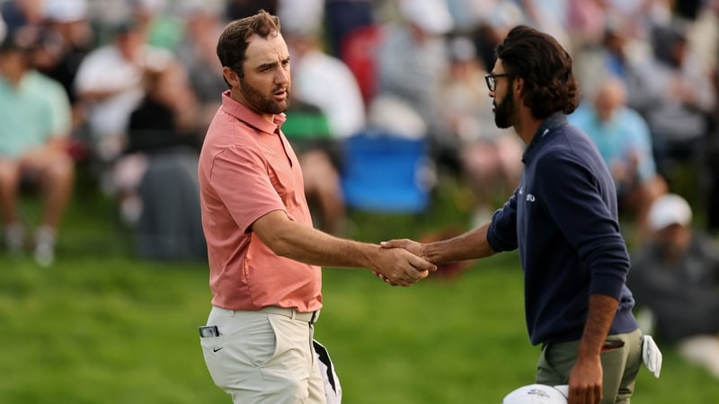 Scottie Scheffler shakes hands with playing partner Akshay Bhatia on the 18th green