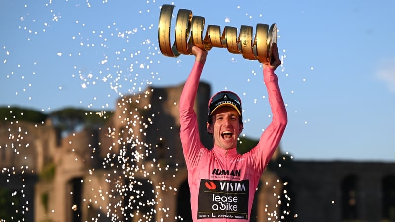 Simon Yates celebrates on the podium