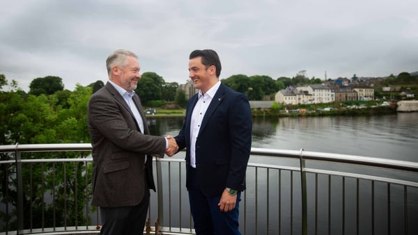 malcolm bell of envetec and kevin walsh of chemishield shaking hands on a bridge