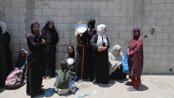 DEIR AL-BALAH, GAZA - JUNE 4: Palestinians, including children, who are struggling with hunger, wait in line to receive hot meals distributed by the charity organizations while Israel's destructive attacks on the Gaza Strip continue as the humanitarian cr