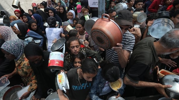 DEIR AL-BALAH, GAZA - JUNE 4: Palestinians, including children, who are struggling with hunger, wait in line to receive hot meals distributed by the charity organizations while Israel's destructive attacks on the Gaza Strip continue as the humanitarian crisis in the region is increasing at Nuseirat