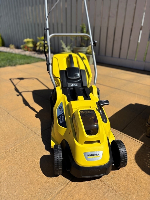 a yellow lawnmower on a patio