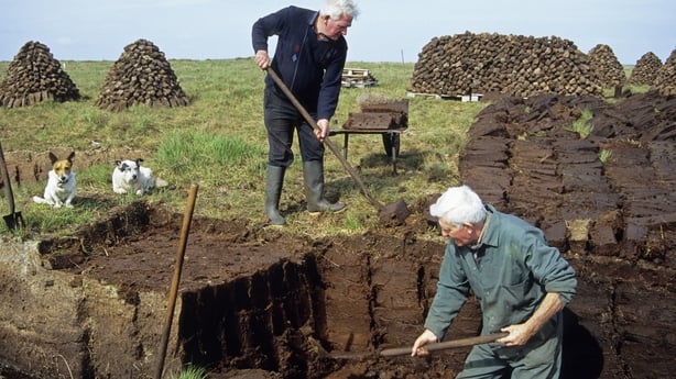 "Men cutting turf from bog in Maamturk Mountains near Cong, Ireland"