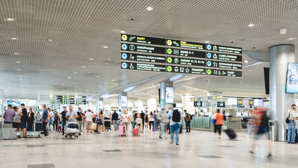 MOSCOW, RUSSIA - June 28, 2021. Crowd of moving people with luggage trolleys on 1st floor at Domodedovo airport hall. Travel or immigrate. Long exposure.