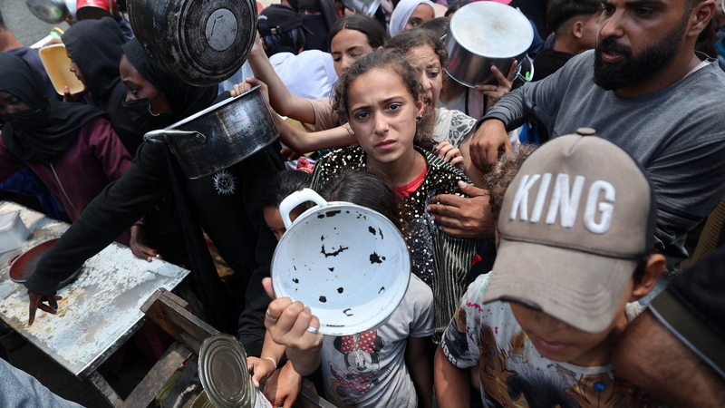 Palestinian children gather at a hot meal distribution point in Nuseirat in the central Gaza Strip