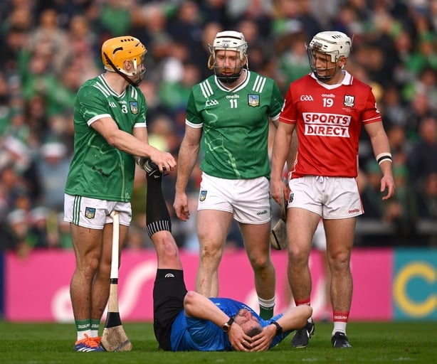 7 June 2025; Cian Lynch of Limerick and Tommy O'Connell of Cork look on as referee Thomas Walsh is attended to by Adam English of Limerick during the Munster GAA Hurling Senior Championship final match between Limerick and Cork at LIT Gaelic Grounds in Limerick. Photo by Ray McManus/Sportsfile