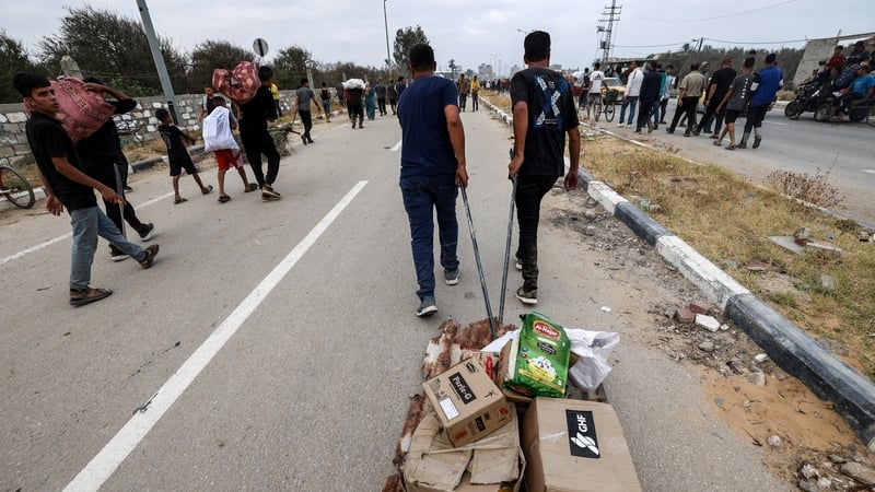 People carry relief supplies from a Gaza Humanitarian Foundation aid distribution spot in central Gaza