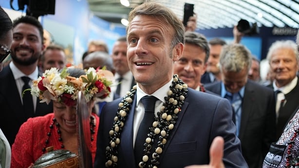 France's President Emmanuel Macron (R) visits the French Polynesia stand at "La Baleine" (The Whale) exhibition centre one day ahead of the opening of the third UN Ocean Conference (UNOC) a high-level summit on ocean conservation, as nations face pressure to adopt tougher stances on overfishing, pol