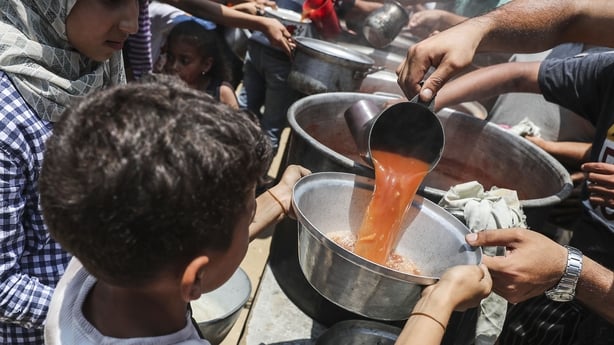 GAZA STRIP - JUNE 7: Palestinians, including children, who are struggling with hunger, wait in line to receive hot meals distributed by the charity organizations while Israel's destructive attacks continue during the second of Eid al Adha in the Gaza Strip on June 7, 2025. (Photo by Mahmoud Issa/Ana