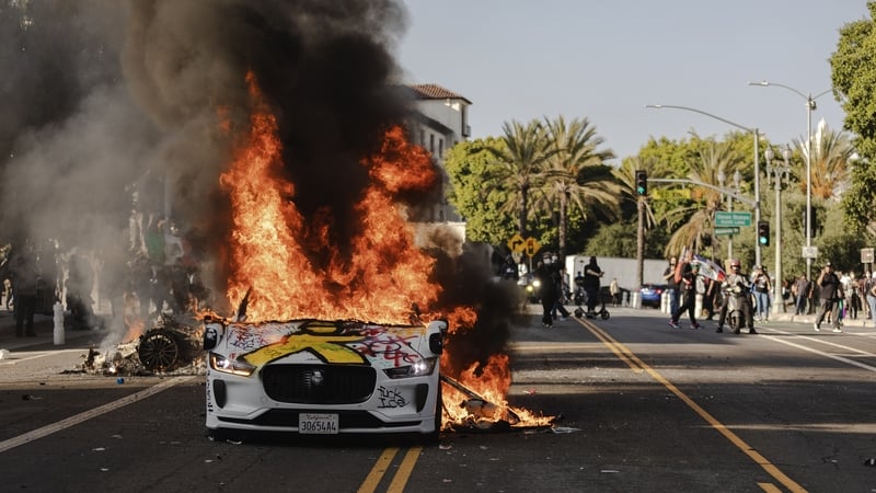 LOS ANGELES, CALIFORNIA - JUNE 8: Several cars burn on North Los Angeles street during clashes between protesters and police on June 8, 2025 in Downtown Los Angeles, California. The clashes come after ICE raids swept throughout the city over the weekend.