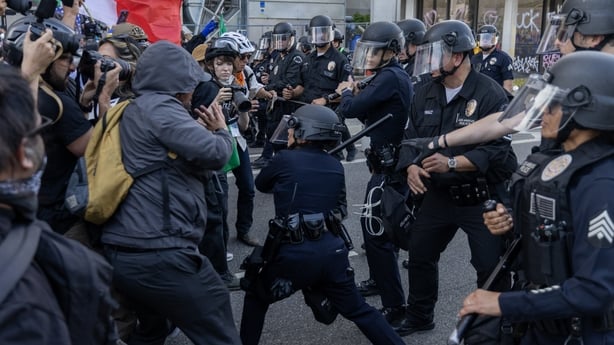 LOS ANGELES, CALIFORNIA - JUNE 09: A police officer wields her club at people facing police as protests continue in Los Angeles following three days of clashes with police after a series of immigration raids on June 09, 2025 in Los Angeles, California. Tensions in the city remain high after the Trum