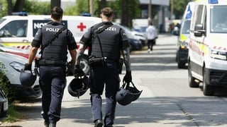 Two policemen walk past ambulance cars in a street close to a school where, according to reports, several people died in a shooting, on June 10, 2025 in Graz, southeastern Austria. Several people died in a school shooting, including the attacker, Austrian