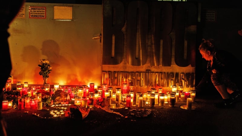 People light candles at the school in memory of the dead and injured