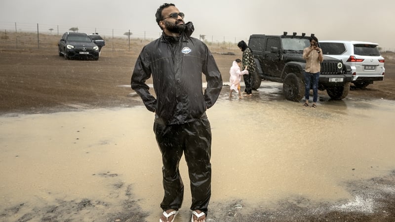 Muhammed Sajjad stands in the rain with others who took part in a 'rain chase' in Sharjah