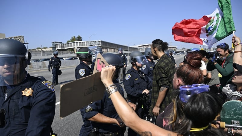 Officers disperse protesters near the Metropolitan Detention Center and Federal Building in Los Angeles