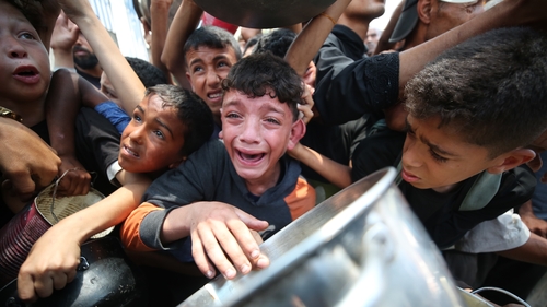 A child is seen crying as crowds surge while food is distributed by a charity organisation in Gaza City