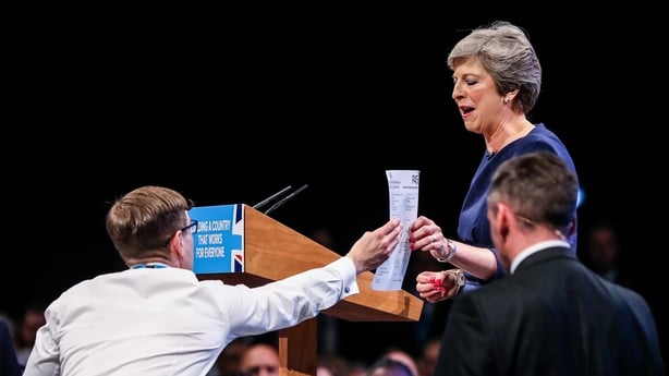 FILE: Simon Brodkin, comedian, hands Theresa May, U.K. prime minister and leader of the Conservative Party, a fake P45 tax document given to former employees of a company, as she delivers her speech at the party's annual conference in Manchester, U.K., on Wednesday, Oct. 4, 2017. An emotional Theres