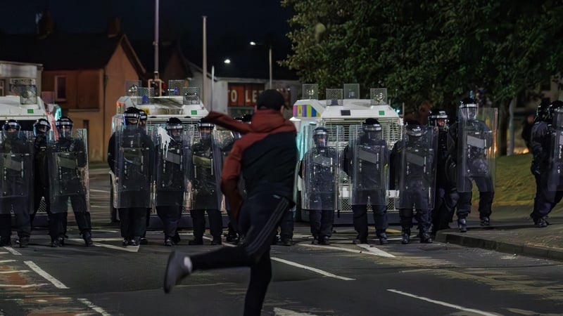 A youth throws an object at officers from the PSNI with riot shields during a third night of disorder in Ballymena