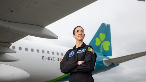 Dr. Norah Patten, Irish aeronautical engineer, standing in front of an Aer Lingus plane