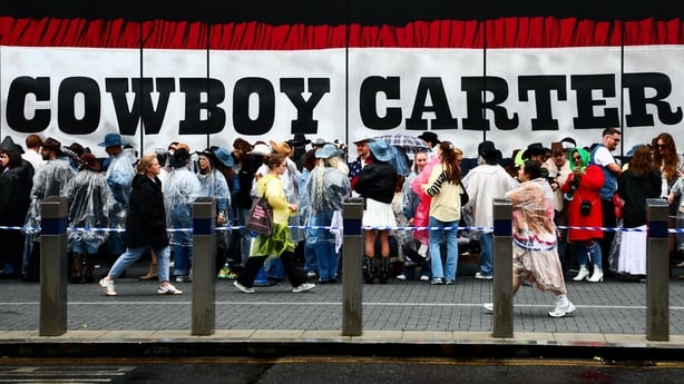 Beyonce fans, also known as the "BeyHive", queue in the rain for entry at Tottenham Hotspur Stadium 