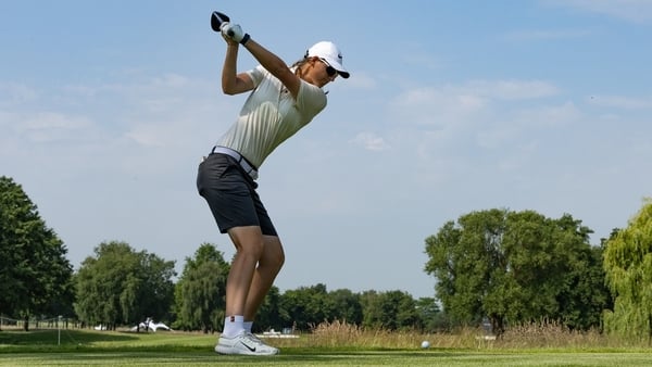 a person swinging a golf club