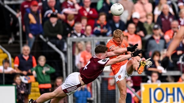 14 June 2025; Cian McConville of Armagh kicks a two-point score despite the tackle of Jack Glynn of Galway during the GAA Football All-Ireland Senior Championship Round 3 match between Galway and Armagh at Kingspan Breffni in Cavan. Photo by Ben McShane/Sportsfile
