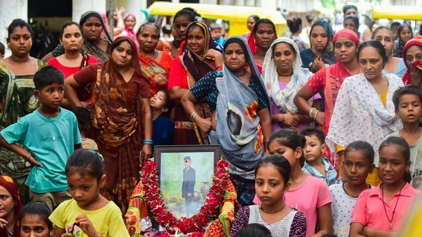 AHMEDABAD, INDIA - JUNE 15: Relatives and neighbors of Akash Patni, a 14 years old tea vendor who died in Air India Boeing 787 Crash, mourn as they wait for the dead body at his residence, on June 15, 2025 in Ahmedabad, India. An Air India Boeing 787 Dreamliner, flight AI-171, carrying 242 passenger