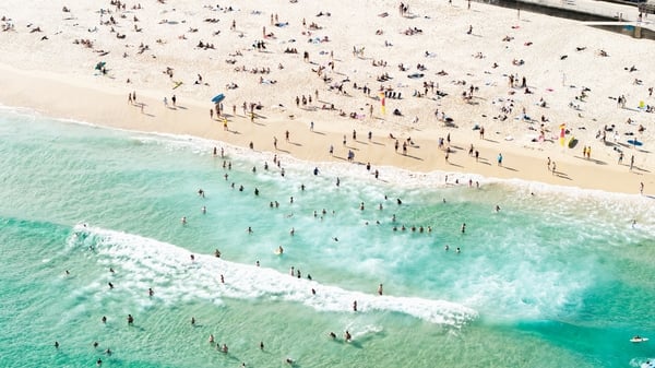 Bondi Beach, located in Sydney, Australia, is one of the world’s most iconic beaches. This scene captures swimmers enjoying the pristine waters in the distance, highlighting the beach’s lively atmosphere and natural beauty. Known for its golden sands and