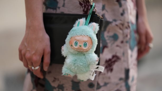 PARIS, FRANCE - JUNE 12: Close-up detail view of a green "Serenity" Labubu fluffy monster plush doll / charm with big teeth from the "Big Into Energy" collection, during a street style fashion photo session, on June 12, 2025 in Paris, France. (Photo by Edward Berthelot/Getty Images)