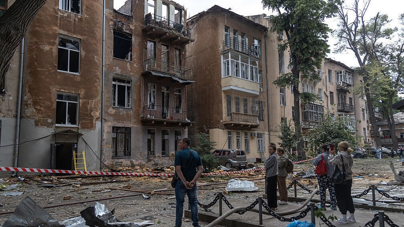Local residents look at damaged residential buildings following a Russian drone attack in Odesa overnight