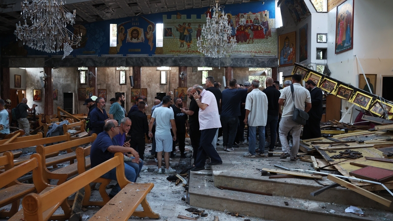 People survey the damage inside the Mar Elias Church