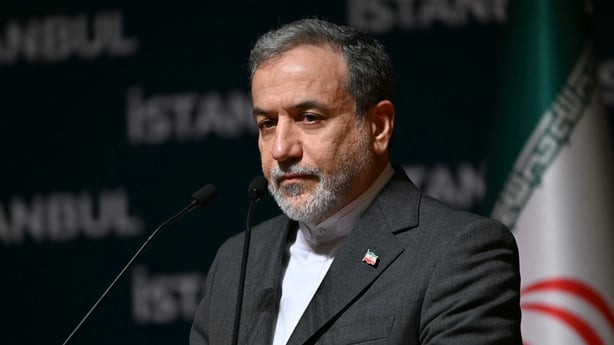 Iran foreign minister Abbas Araghchi standing in front of an Iranian flag.