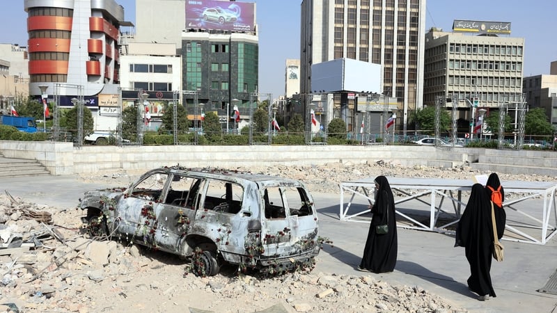 Iranians check on an ambulance that was destroyed during an Israeli strike on Tehran