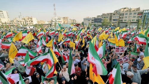 Iranians wave national flags and chant slogans as they celebrate a ceasefire between Iran and Israel