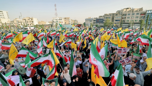 Iranians wave national flags and chant slogans as they celebrate a ceasefire between Iran and Israel