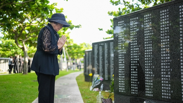 A woman prays for lost loved ones while visiting the Peace Memorial Park to mark the 80th anniversary of the Battle of Okinawa in Itoman, Okinawa Prefecture on June 23, 2025. The three-month battle, often dubbed the "Typhoon of Steel", killed about 200,000 people, almost half of them local civilians