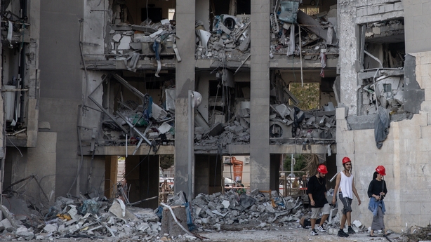 BEERSHEBA, ISRAEL - JUNE 24: People walk through a building where four people were killed by an Iranian missile strike on June 24, 2025 in Beersheba, Israel. According to Israeli authorities, Iran launched a barrage of missiles in the early hours this morning, before the start of a U.S.-brokered cea