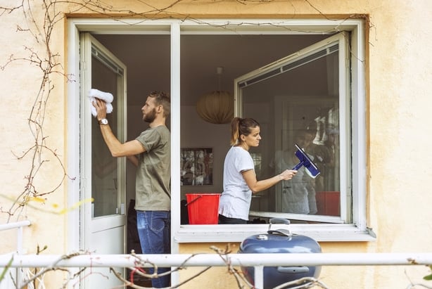 a man and a woman cleaning a window together