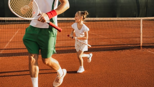 young tennis player and coach on clay court