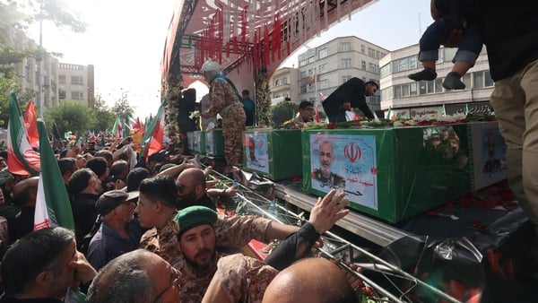 Mourners reach out to touch the coffins of military commanders during the funeral procession