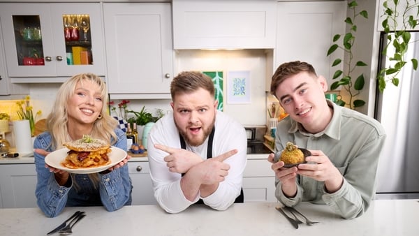 a group of people sitting at a table pointing at food