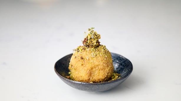 a Deep-Fried Pistachio & Sun-Dried Tomato Ice Cream Bomb on a plate