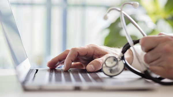 Doctor entering patient notes on a laptop in surgery