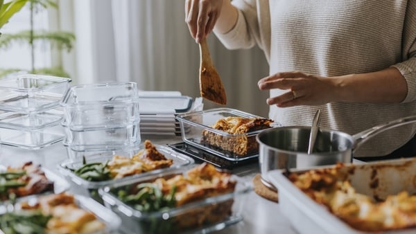 Woman weighing lunch boxes as part of healthy meal prep