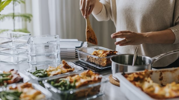 Woman weighing lunch boxes as part of healthy meal prep