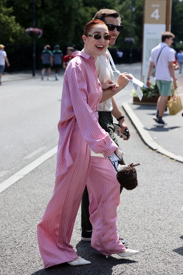 a person wearing pink jumpsuit and sunglasses