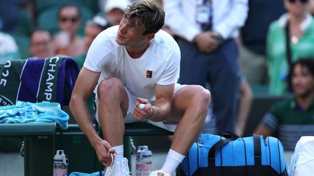 Jack Draper of Great Britain changes his shoes following his victory after his opponent, Sebastian Baez of Argentina retired during the Gentlemen's Singles first round match on day two of The Championships Wimbledon 2025 at All England Lawn Tennis and Croquet Club on July 01, 2025 in London, England