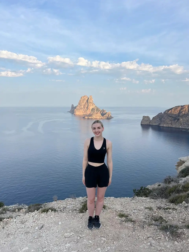 Camilla Foster on a sunrise hike posing next to Es Vedrà (Camilla Foster/PA)