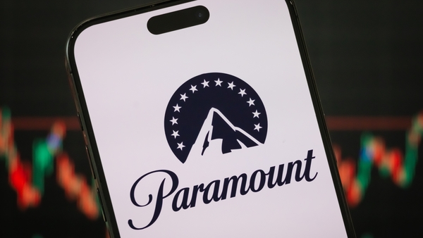 CHONGQING, CHINA - FEBRUARY 23: In this photo illustration, the Paramount logo is displayed on a smartphone screen, with the company’s latest stock market performance and candlestick charts visible in the background, highlighting Paramount’s real-time fin